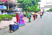 লকডাউনে হেঁটে ক্লান্ত শিশুটি ঘুমিয়ে পড়ল সুটকেসের ওপরেই