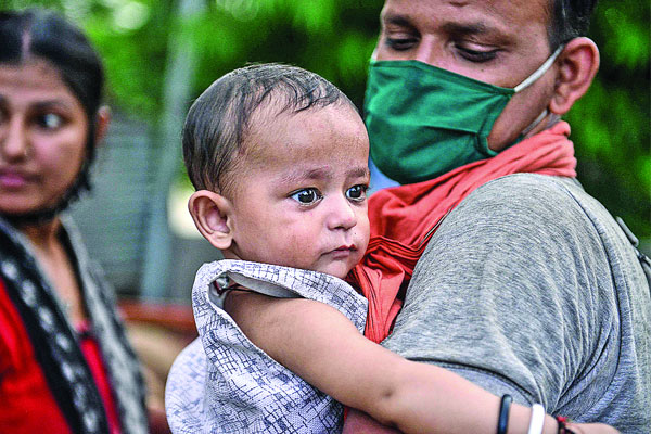 বাড়িতে যাওয়ার পথে সন্তানকে নিয়ে একজন শ্রমিক