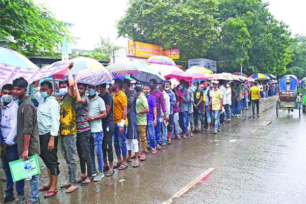 বৃষ্টি উপেক্ষা করে ভ্যাকসিন নিতে আসা প্রবাসীদের দীর্ঘ লাইন